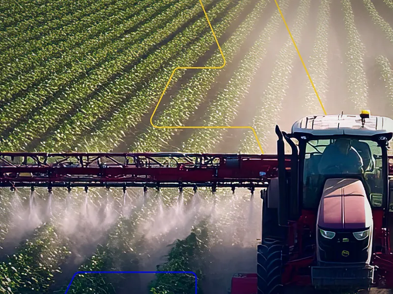 Trator pulverizando uma lavoura, com as linhas da marca da JA Capacitação