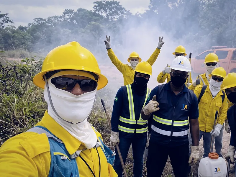 Turma de brigadistas florestais de uniforme amarelo com o instrutor da JA Capacitação, depois do treinamento de combate a incêndio